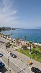 a street with cars parked on a road next to the ocean at Alexandros Kalamos Hotel in Áyioi Apóstoloi +7 photos