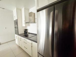 una cucina con un grande frigorifero in acciaio inossidabile di Penthouse w/ Terrace, Grill & City Views a Monterrey
