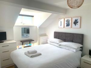 a bedroom with a large white bed and a television at West Street Mews - Serviced Accommodation in Exeter
