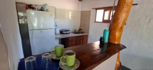 a kitchen with a wooden table and a white refrigerator at Campo Domingo in Tinogasta