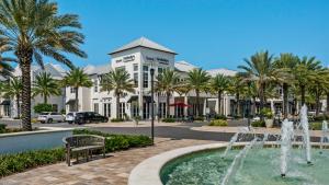 a fountain in front of a building with palm trees at Seacrest Townhomes 7 - Sol and Sea in Seacrest