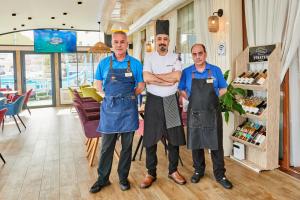 three men in aprons standing in a store at Petar and Pavel Hotel & Relax Center in Pomorie