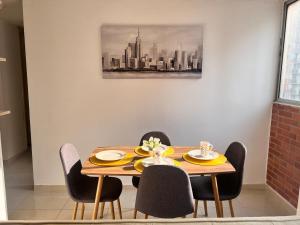 a dining room table with chairs and a painting on the wall at Max House 503 in Soledad