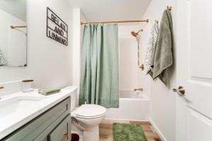 La salle de bains est pourvue d'un rideau de douche vert et de toilettes. dans l'établissement Walk to Lake Pet-Friendly Cottage in Jamestown!, à Hartstown 20 autres photos
