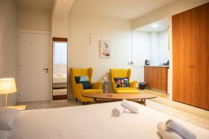 a room with a bed and two chairs and a table at Spacious studio located in the pedestrian zone in Nicosia