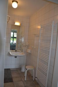 a bathroom with a sink and a mirror and a stool at Brunnenhaus Wohnung 1 in Mellenthin