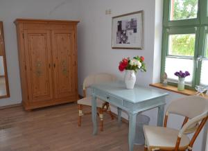 a blue table with a vase of flowers on it at Brunnenhaus Wohnung 1 in Mellenthin