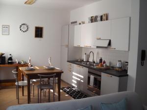 a kitchen with a small table and a kitchen with white cabinets at APPARTAMENTO ACERO - 2 min walk to Bernina Express - 150metri in Tirano