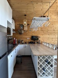 una cocina con armarios blancos y una encimera grande en Samshvilde Hideaway, en Daghetʼkhachʼini 16 fotos más
