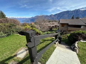 a wooden bench sitting in the grass with mountains in the background at Breva's Flat near Bellagio in Bellagio