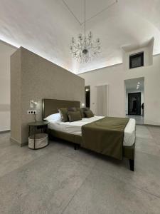 Habitación grande con cama grande y lámpara de araña. en Le Gioie di Monica Casa Vacanze per Pompei, en Boscotrecase