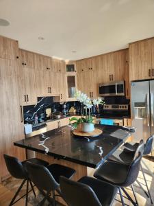 eine Küche mit einer großen Insel mit Stühlen und einem Kühlschrank in der Unterkunft Cozy front lake cottage! in Hindon Hill