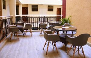 a patio with tables and chairs on a balcony at Divine Homes Resort Kisumu in Kisumu