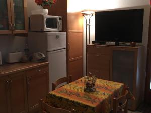 a small kitchen with a table and a television at Gîte cosy avec terrasse pour 4 pers, proche lac d'Esparron - FR-1-822-14 in Saint-Martin-de-Brômes +2 photos