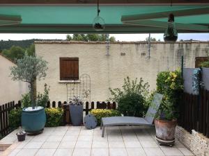 a patio with a bench and some plants and a building at Gîte cosy avec terrasse pour 4 pers, proche lac d'Esparron - FR-1-822-14 in Saint-Martin-de-Brômes
