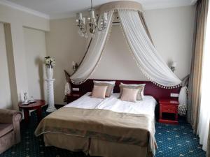 sypialnia z dużym łóżkiem z baldachimem w obiekcie Parisel Palace Centrum Konferencyjno-Wypoczynkowe Klimki pod Łukowem w Łukowie