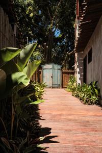 einen Holzsteg, der zu einem Gebäude mit einer blauen Box führt in der Unterkunft Caraíva Villas de Jardel - Casa Jeri in Caraíva