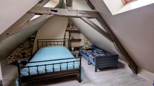 a attic room with a bed and a bed sqor at À la campagne proche du Mans in Louplande
