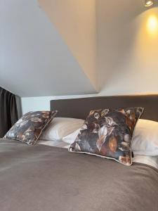 a bed with two pillows on top of it at Sun Park - Apartamenty in Pobierowo +26 photos