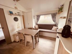 a small room with a table and a couch at Mobil Home Oliviers 2 in Valras-Plage