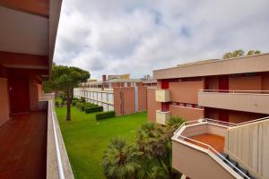a balcony of a building with a green yard at Appartamento in residence con piscina in Marina di Bibbona