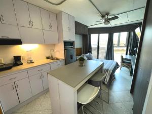 a kitchen with white cabinets and a bed in a room at Estudios by Flor y tierra in Guadalajara