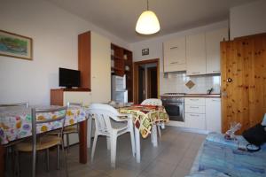 a kitchen with a table and chairs and a kitchen with a table and a kitchen at Appartamento in residence con piscina in Marina di Bibbona