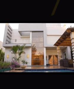 una gran casa blanca con una piscina frente a ella en فيلا فاخرة بحمام سباحة جراند هايتس, en Seis de Octubre