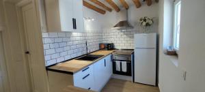 a kitchen with white cabinets and a white refrigerator at Casas las Lanzas 1 in Setenil