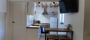 a kitchen with a table and a white refrigerator at Casas las Lanzas 1 in Setenil +3 photos