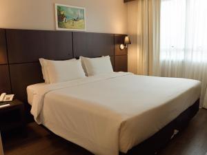 a large white bed in a hotel room at Bourbon Convention Hotel Ponta Grossa in Ponta Grossa