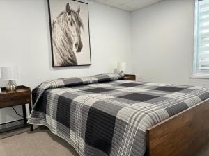a bedroom with a bed with a horse picture on the wall at Les studios de la mer in Matane