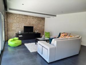 a living room with a white couch and a tv at O Refúgio - Gerês in Souto