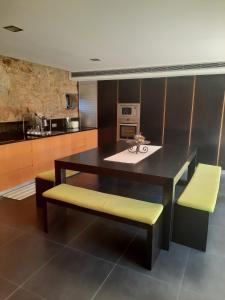 a kitchen with a table and two yellow chairs at O Refúgio - Gerês in Souto