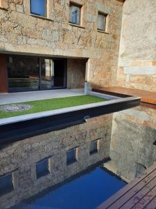 a pool of water in front of a building at O Refúgio - Gerês in Souto