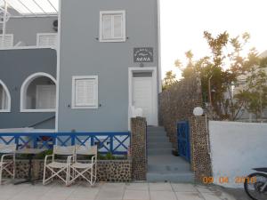 a white building with two chairs and a door at Rooms to let Rena in Monolithos