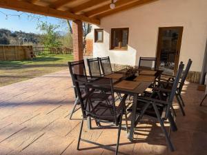 a wooden table and chairs on a patio at Casa Rural Can Ricós - El Mirador del Montseny in Vallgorguina