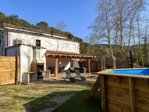 a backyard with a pool and a house at Casa Rural Can Ricós - El Mirador del Montseny in Vallgorguina