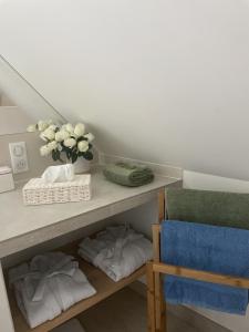 a room with a shelf with towels and a vase of flowers at Villa Cassandre in Esvres