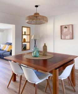 a dining room table with white chairs and a couch at Ventura Beach by Best Holidays Fuerteventura in Corralejo