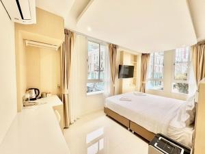 a bedroom with a bed and two windows at ABCQQ Hotel Bangkok in Bangkok