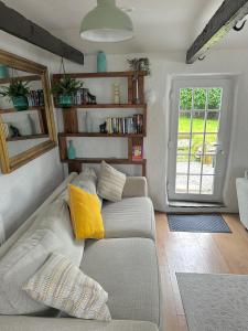 a living room with a couch and a window at Romantic log-burner Cornish Cottage private garden dogs welcome in Truro +43 photos