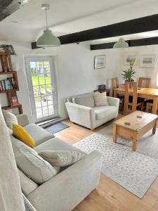 un soggiorno con un divano e un tavolo di Romantic log-burner Cornish Cottage private garden dogs welcome a Truro Altre 40 foto