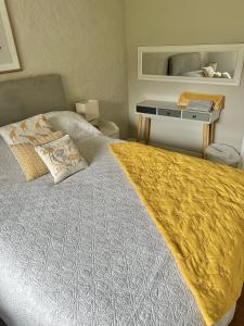 una camera da letto con un grande letto con una coperta gialla di Romantic log-burner Cornish Cottage private garden dogs welcome a Truro