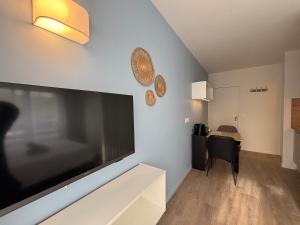 un salon avec une grande télévision à écran plat dans l'établissement Le D'Artagnan - App 8 - Balcon, à Cazaubon