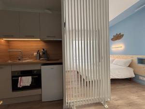 une chambre avec un lit bébé dans une cuisine avec un lit dans l'établissement Le D'Artagnan - App 8 - Balcon, à Cazaubon