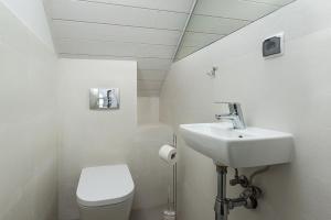 a white bathroom with a sink and a toilet at Domki Morski Raj B in Dębki +23 photos