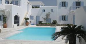 a large swimming pool in front of white buildings at Mimoza Collection suites in Ornos