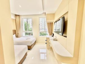 a hotel room with two beds and a tv at ABCQQ Hotel Bangkok in Bangkok