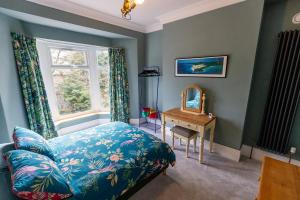 バクストンにあるCLIFTON BANK - Characterful & Cosy Home in Buxton, Peak Districtのベッドルーム1室(ベッド1台、窓、デスク付)